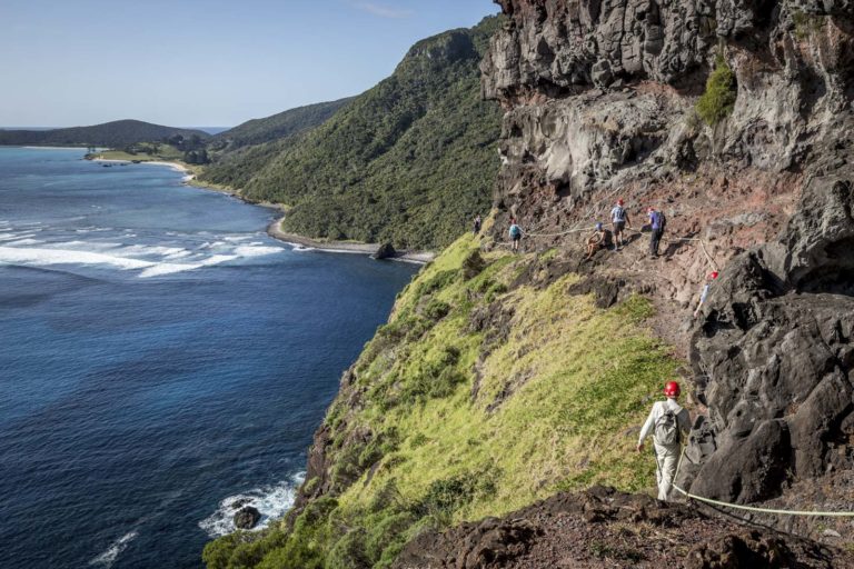 Walkers on the dramatic Lower Road below Mt Lidgbird, Lord Howe Island